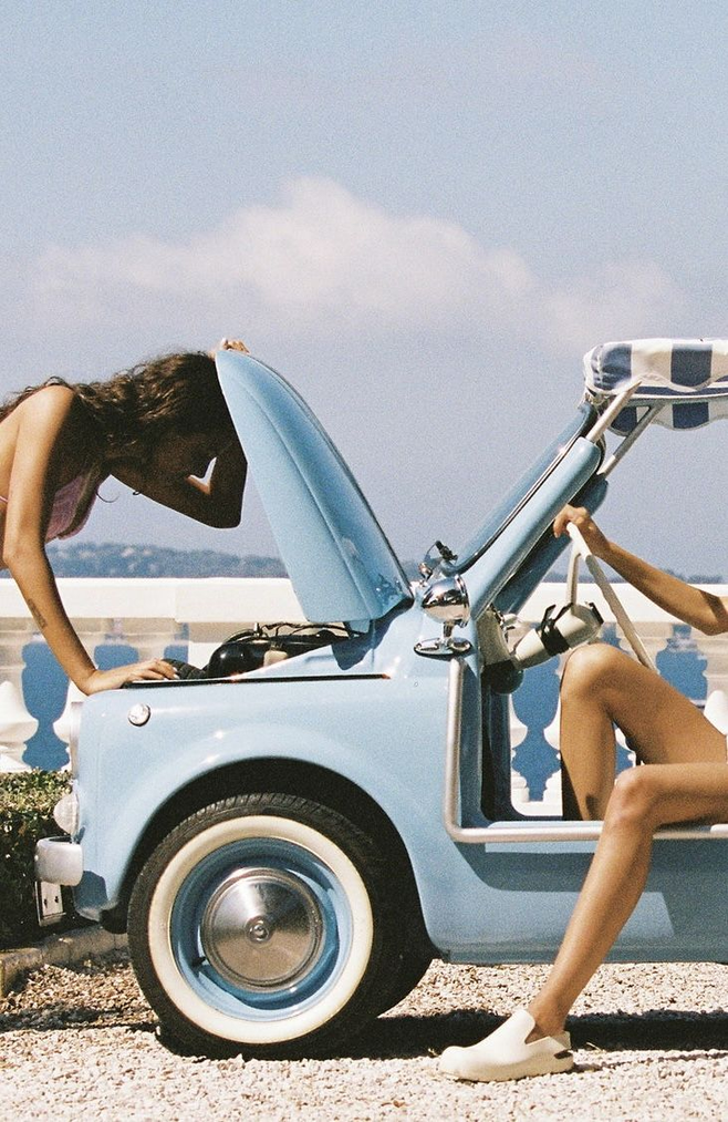 A blue vintage car by the coast